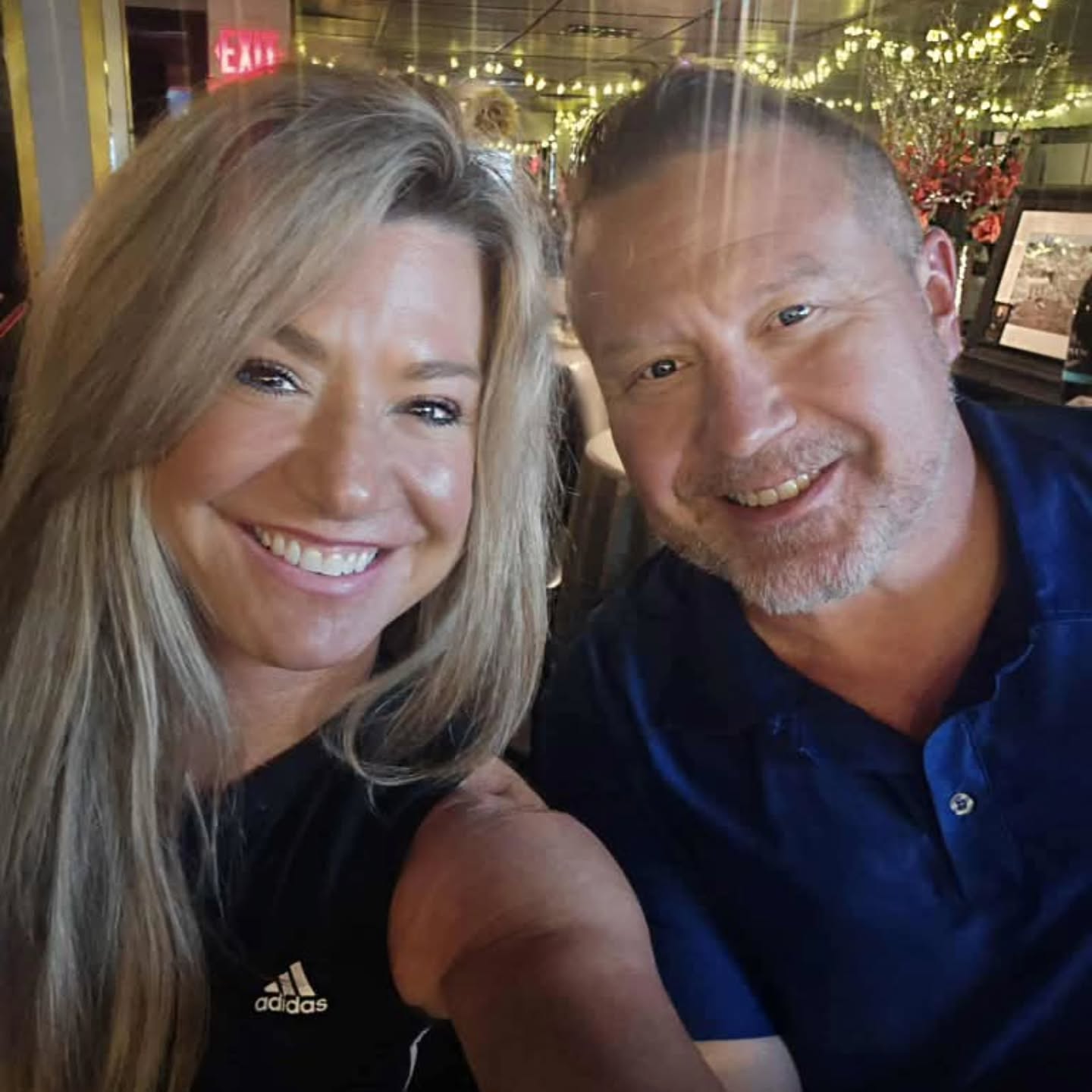 Candi and Greg smiling together at a restaurant